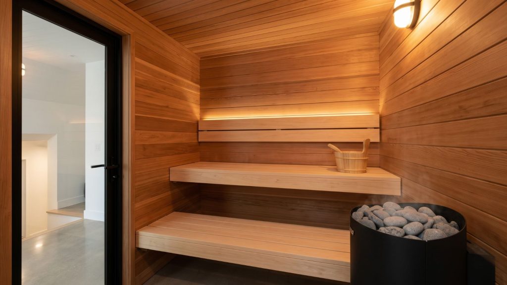 Scandi house style custom home sauna with cedar walls and glass door Minnesota lower level